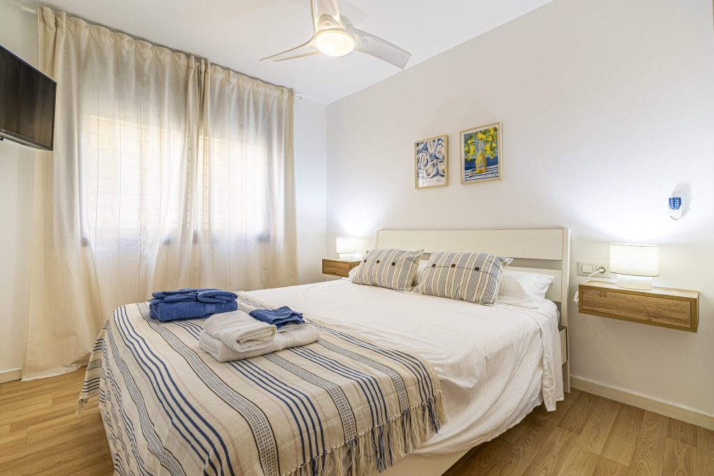 Interior moderno del apartamento turístico en Pedregalejo Málaga, con cocina equipada, salón decorado con motivos marineros, smart TV y aire acondicionado.